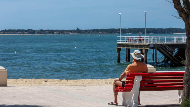 senior man sitting on a bench looking at the sea