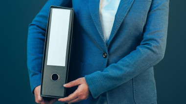 Business company accountant holding document binder with archived paperwork and other corporate legal sheets