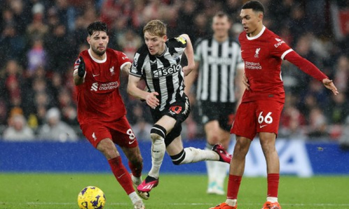 Liverpool, England, 1st January 2024. Anthony Gordon of Newcastle United runs between Dominik Szoboszlai and Trent Alexa