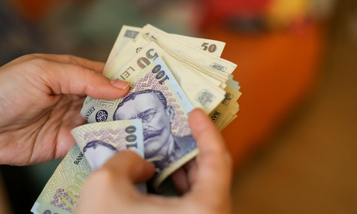 Details with the hands of a young lady counting banknotes of 50 and 100 Romanian Lei currency