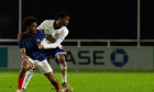 St Georges Park, England, 26th March 2024: Stephen Mfuni (5) for England holding back Rayane Messi (9) for France during
