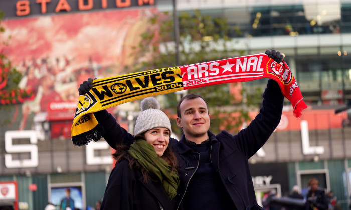 Fans with a match half and half scarf outside the ground ahead of the Premier League match at the Emirates Stadium, London. Picture date: Saturday December 2, 2023.