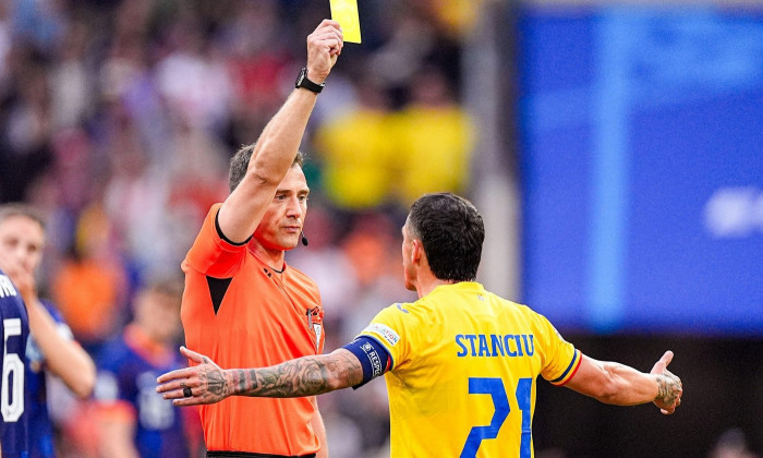 Munich, Germany. 02nd July, 2024. MUNICH, GERMANY - JULY 2: Referee Felix Zwayer shows a yellow card due to argument to Nicolae Stanciu of Romania during the Round of 16 - UEFA EURO 2024 match between Romania and Netherlands at Munich Football Arena on Ju