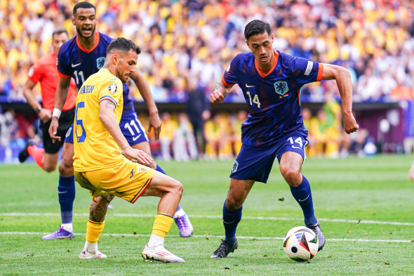 Munich, Germany. 02nd July, 2024. MUNICH, GERMANY - JULY 2: Marius Marin of Romania battles for possession with Tijjani Reijnders of the Netherlands during the Round of 16 - UEFA EURO 2024 match between Romania and Netherlands at Munich Football Arena on