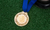 Football, trophy and medal on artificial grass