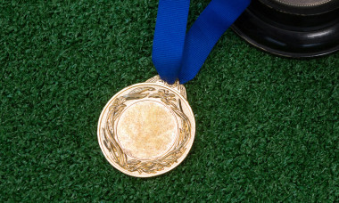 Football, trophy and medal on artificial grass