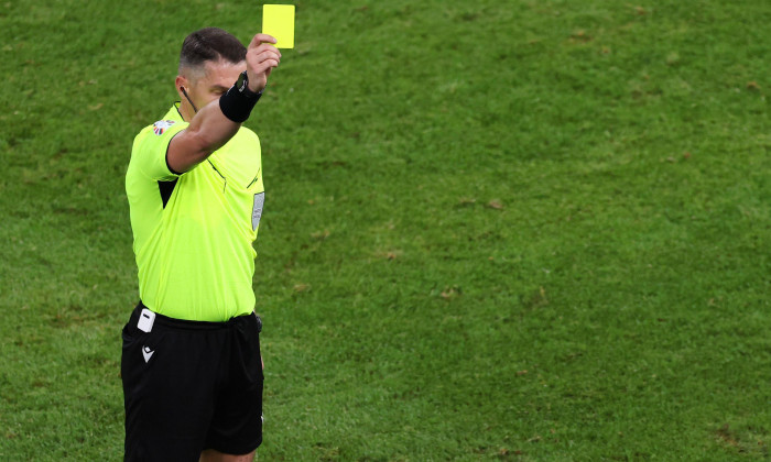 Hamburg, Germany. 26th June, 2024. Soccer: Football, UEFA Euro 2024, European Championship, Czech Republic - Turkey, Preliminary round, Group F, Matchday 3, Volksparkstadion Hamburg, Referee Istvan Kovacs from Romania shows a yellow card. Credit: Jens Btt