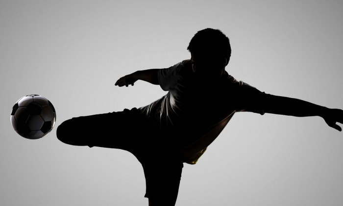 silhouette soccer player kicking the ball