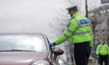 Bucharest, Romania - March 25, 2020: Romanian road police officer pulls over a car to check for the drivers identity papers.