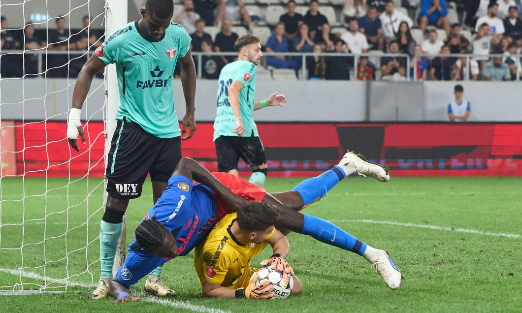 Bucharest, Romania. 1st Sep, 2024: Joyskim Dawa (top) of FCSB falls over UTA goalkeeper Robert Popa during the football match between FCSB and UTA Arad in the 8th round of Superliga, the first league of the Romanian 2024-2025 football championship, at the