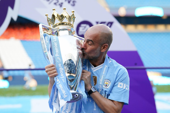 Manchester City manager Pep Guardiola kisses the Premier League trophy after the Premier League match at the Etihad Stadium, Manchester. Picture date: Sunday May 19, 2024.