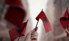 A group of people holding small flags of the Albania in their hands.