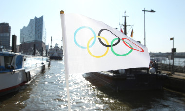 Eine Flagge mit den Olympischen Ringen hängt an einer Brücke im Hamburger Hafen. Im Hintergrund das Konzerthaus Elbphilh