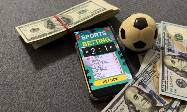 Winning bet on sporting event, money in sport and sports betting conceptual idea with football, soccer ball and cash