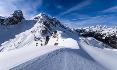 Snowdrift creating artful structures around Giau pass in winter, snow-covered summits of Torre Dusso, Mt. Cernera and Ma