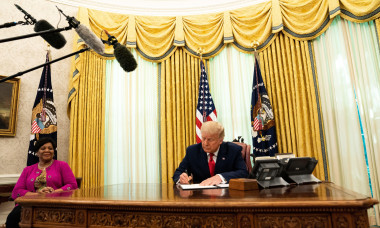 United States President Donald J. Trump signs the document granting Alice Marie Johnson, criminal justice reform advocate, a full pardon in the Oval Office of the White House in Washington, DC. Ms. Johnson looks on from left.Credit: Anna Moneymaker / Pool