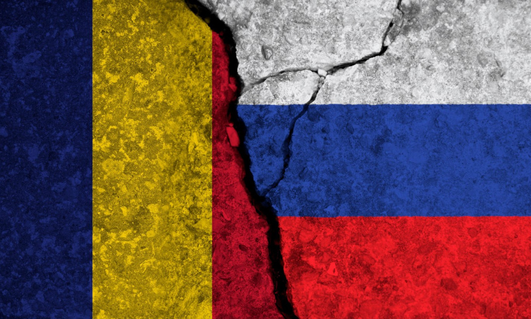 Political relationship between Romania and russia. National flags on cracked concrete background