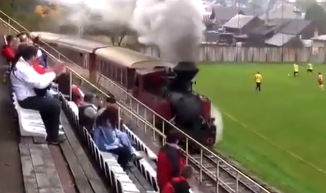 Imagini unice pe un teren de fotbal! Un tren trece prin fața tribunelor, însă meciul continuă