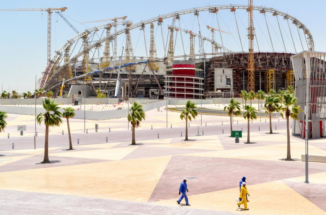 Workers walking past the work of the renovation (roof and cooling) of the Khalifa International Stadium in Doha, Qatar