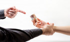 Bribery. A man's hand in a black shirt catches a woman's hand with a bribe. Side view. White background. The concept of the world anti-corruption day.