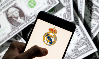 In this photo illustration Spanish professional football club team Real Madrid Club de Ftbol commonly known as Real Madrid logo seen on an Android mobile device screen with the currency of the United States dollar icon, $ icon symbol in the background.