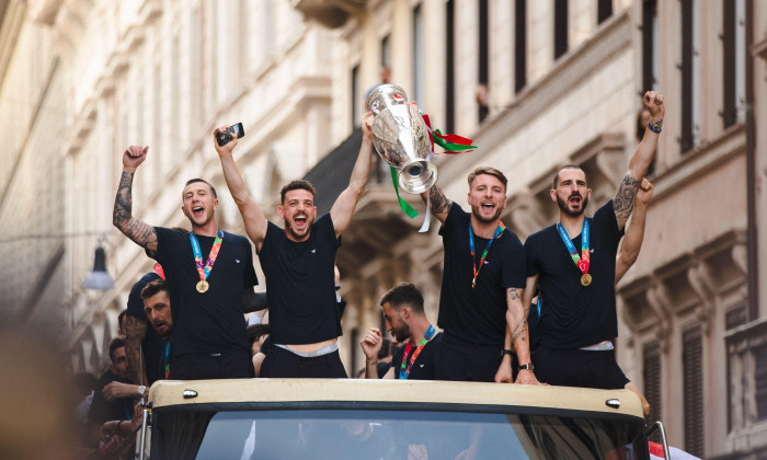 ROME, ITALY - JULY 12, 2021. Federico Bernardeschi, Alessandro Florenzi, Ciro Immobile and Leonardo Bonucci of the Italian national team celebrate the victory at Euro 2020 by exhibiting the European Cup from an open bus with a tour in the center of Rome.