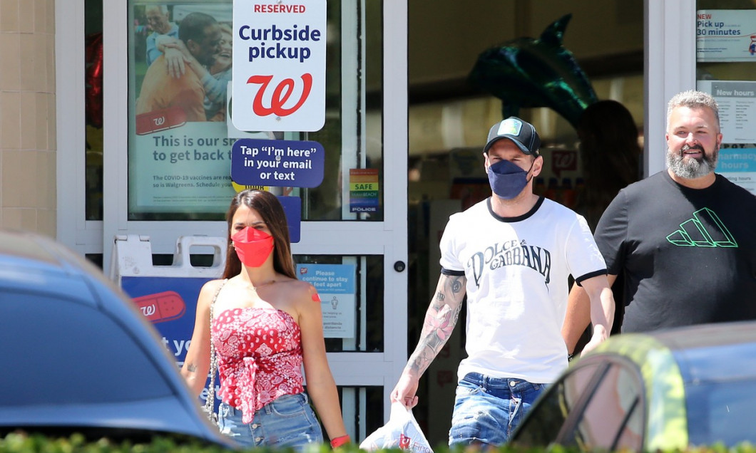 EXCLUSIVE: Argentine football star Lionel Messi and wife Antonella head to a Walgreens pharmacy, presumably to ged a Covid-19 vaccine, and he and his family members later emerged with their red band-aids proudly displayed