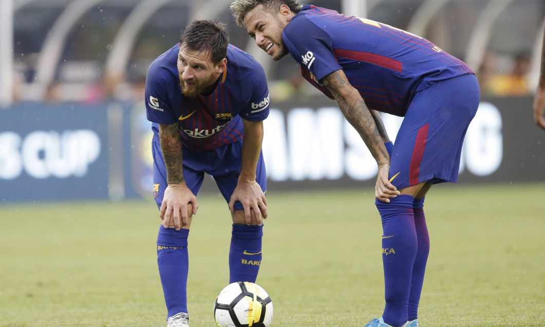 Lionel Messi and Neymar of Barcelona stand on the field