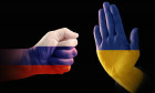 Hands with the flags of Russia and Ukraine, one makes a fist, the other shows a stop gesture, symbolizing the broken relations of the two countries, r