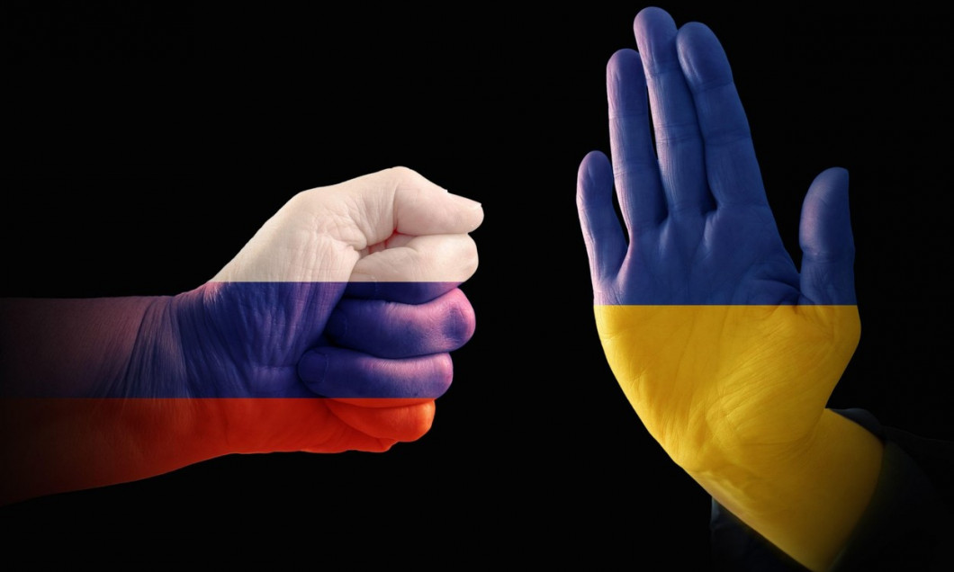Hands with the flags of Russia and Ukraine, one makes a fist, the other shows a stop gesture, symbolizing the broken relations of the two countries, r