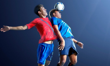 Male soccer players heading ball