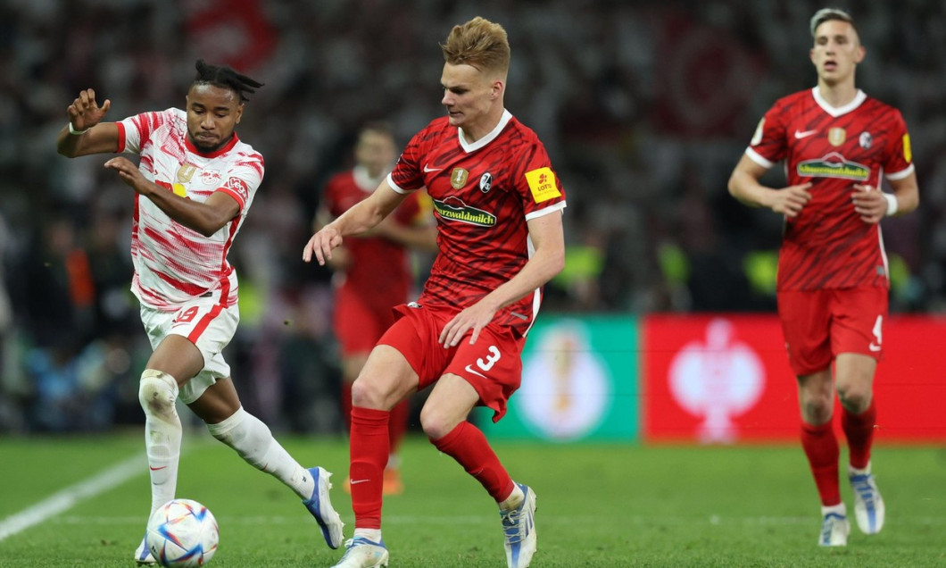 Berlin, Germany. 21st May, 2022. Soccer: DFB Cup, SC Freiburg - RB Leipzig, Final, at the Olympiastadion, Leipzig's Christopher Nkunku (l) and Freiburg's Philipp Lienhart in action. IMPORTANT NOTE: In accordance with the requirements of the DFL Deutsche F