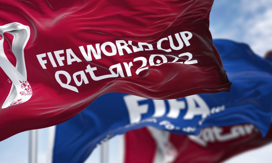 Doha, Qatar, April 2022: Flags with Qatar 2022 World Cup logo and FIFA waving in the wind. The event is scheduled in Qatar from 21 November to 18 Dece