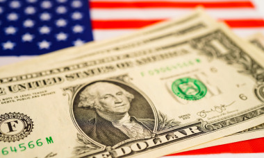 US dollar banknotes money on USA America flag, finance economy concept.