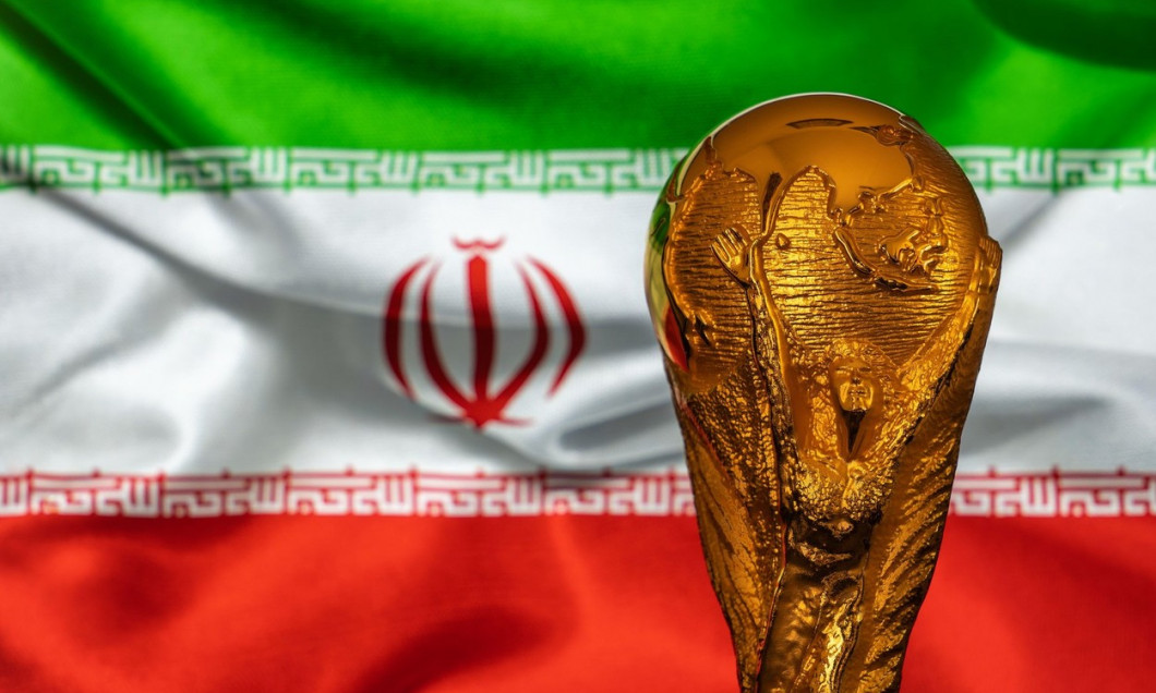 Doha, Qatar - September 4, 2022: FIFA World Cup trophy against the background of Iran flag.