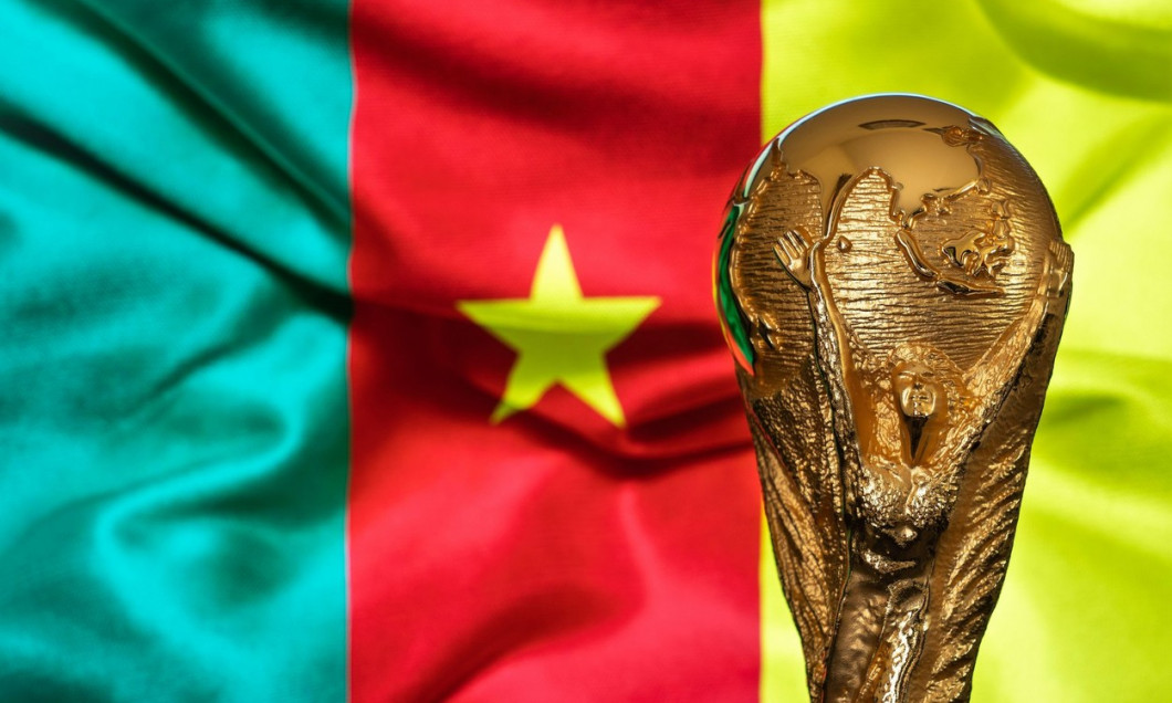Doha, Qatar - September 4, 2022: FIFA World Cup trophy against the background of Cameroon flag.