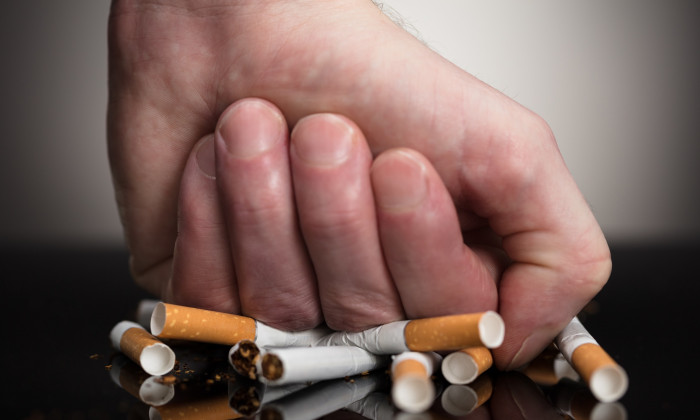 Man's Fist Crushing Cigarettes