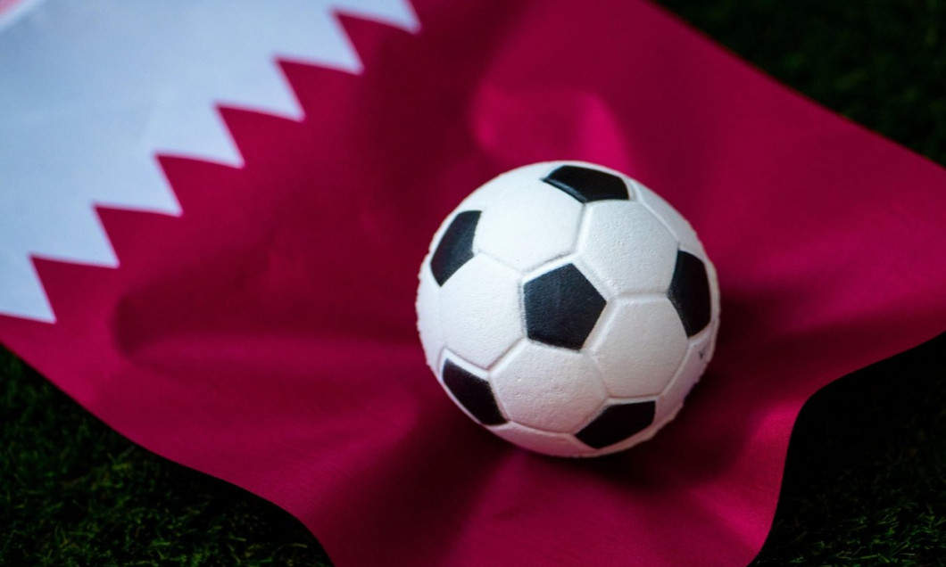 Qatar national football team. National Flag on green grass and soccer ball. Football wallpaper for Championship and Tournament in 2022. World internat