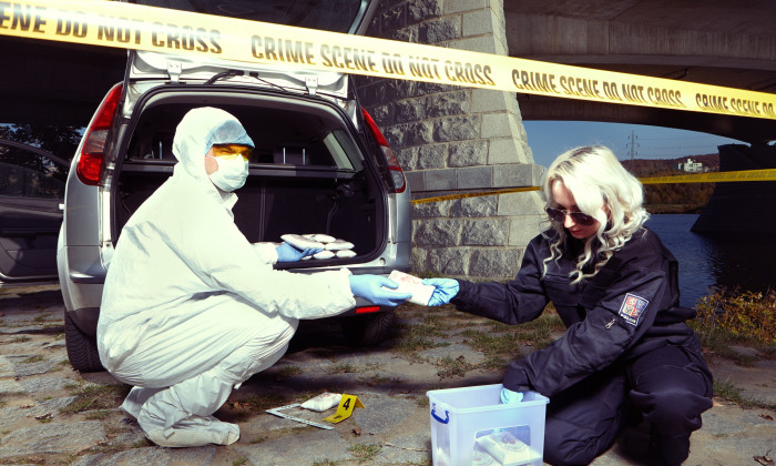 Police packing lot of drugs found in car near river under bridge