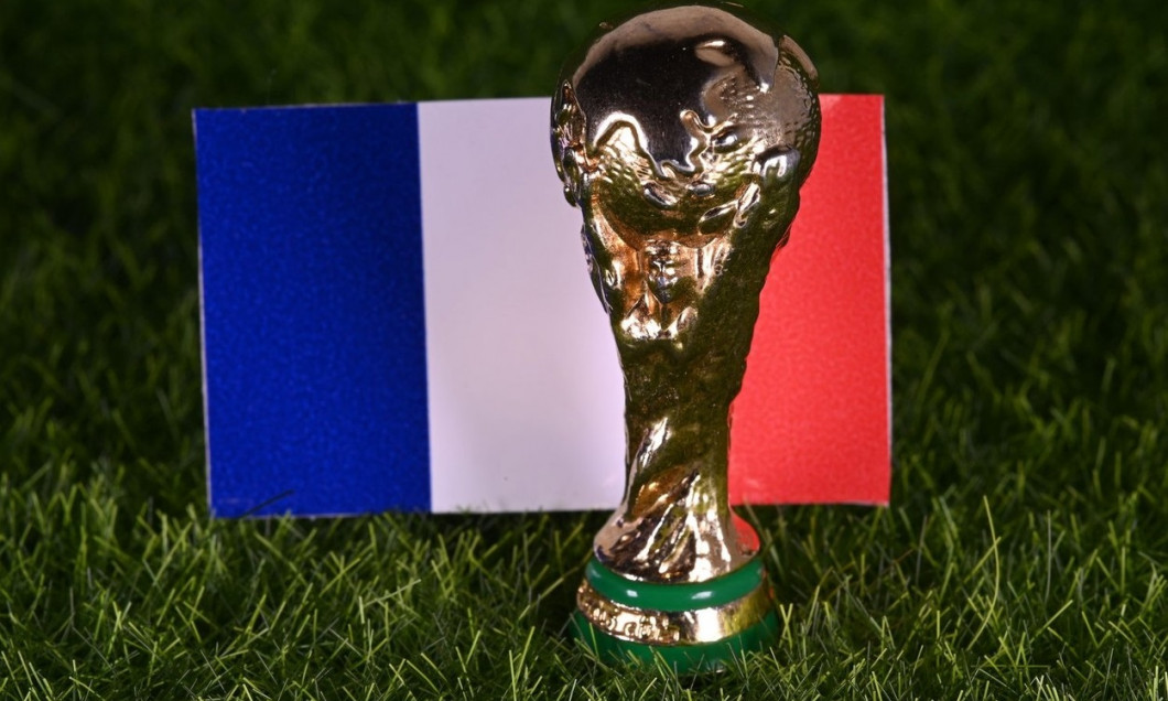 November 13, 2022, Doha, Qatar. FIFA World Cup trophy on the background of the flag of France on the green lawn of the stadium.