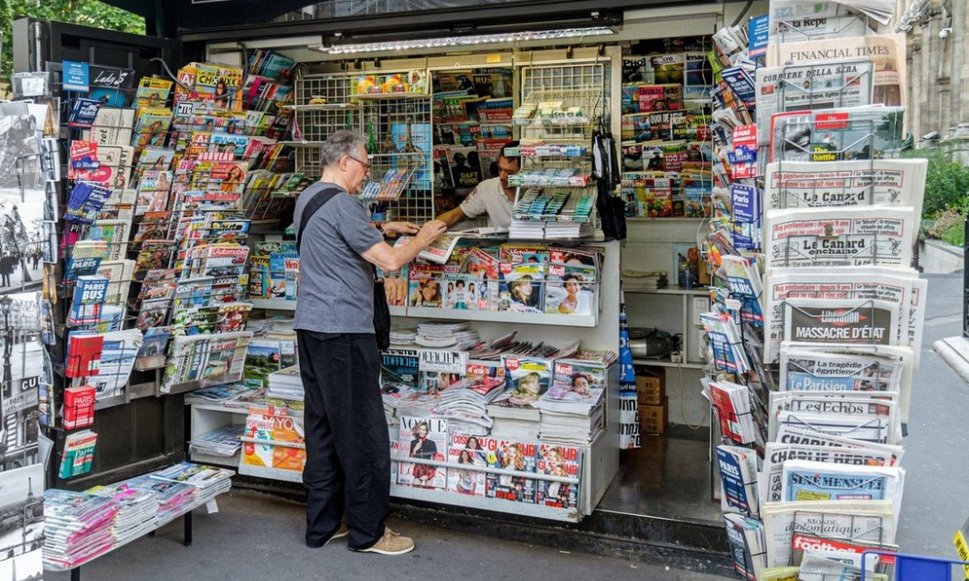 Paris France,4th arrondissement,Rue de Rivoli,newsstand newspapers magazines display sale man buying