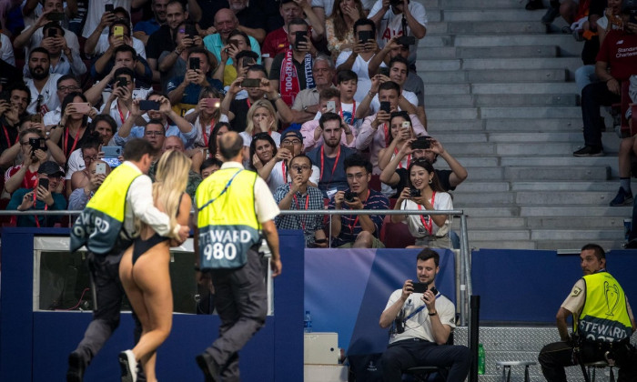 Supporters and staff take photos as streaker Kinsey Wolanski is escorted off the pitch during the UEFA Champions League FINAL match between Tottenham Hotspur and Liverpool at the Metropolitano Stadium (Stadium Metropolitano), Av. de Luis Aragons, 4, 2802