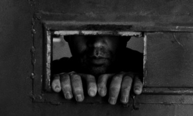INMATE LOOKING THROUGH FROM HIS SMALL CELL S WINDOW, Sinop Prison, Turkey, 06/03/2005