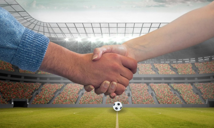 Composition of people shaking hands over sports stadium