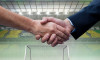 Composition of businessmen shaking hands over sports stadium