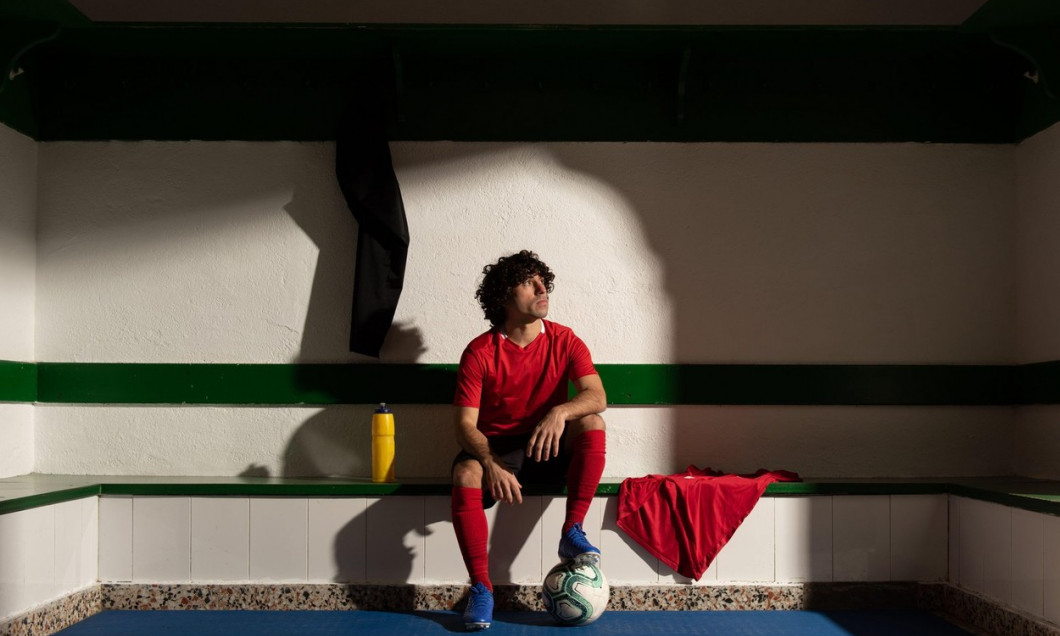 A football player in dressing room with sports uniform