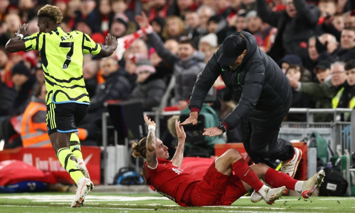 Liverpool, England, 23rd December 2023. Kostas Tsimikas of Liverpool challenges Bukayo Saka of Arsenal and goes crashing