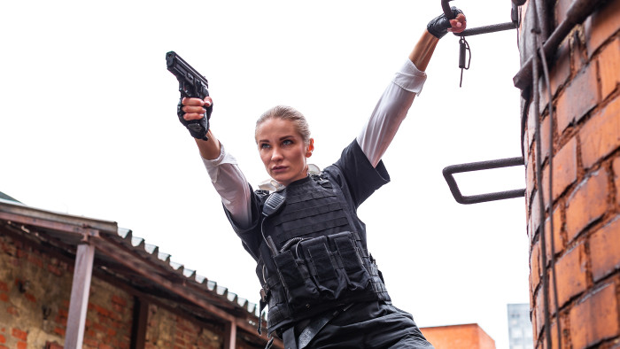 Powerful Woman Holding Gun. War Action Movie Style