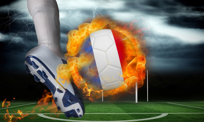 Football player kicking flaming france flag ball