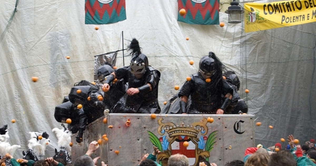 Combatte con le arance durante il carnevale medievale di Ivrea, Italia.  I combattenti avevano 500 tonnellate di frutta